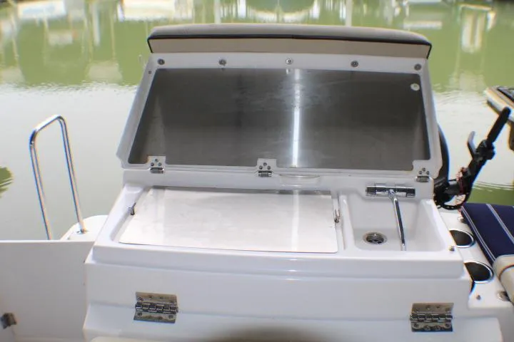 Knot Working Yacht Photos Pics 2020 Ranger Tugs R-27 boat with open storage compartment by the water.