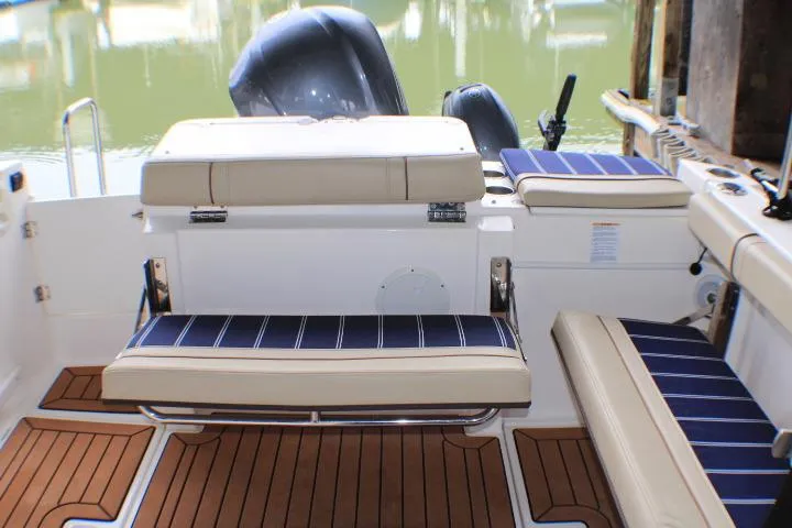 Knot Working Yacht Photos Pics 2020 Ranger Tugs R-27 boat interior with cushioned seating and wood flooring.