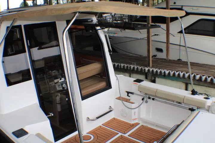 Knot Working Yacht Photos Pics 2020 Ranger Tugs R-27 boat with open cabin door and teak deck.