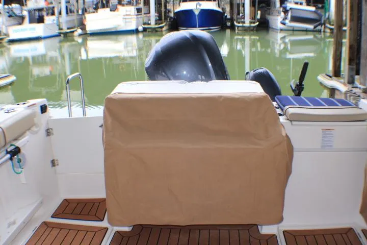 Knot Working Yacht Photos Pics 2020 Ranger Tugs R-27 boat stern view with covered engine at marina.