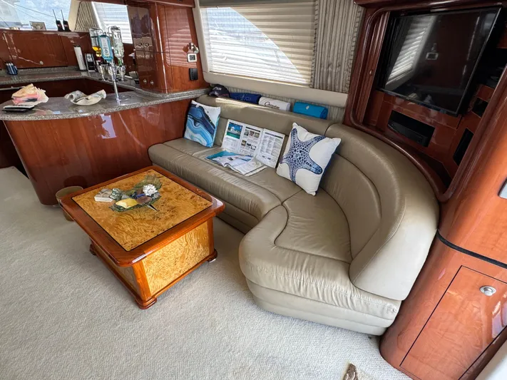 Aqueous Ubiquitous Yacht Photos Pics Luxurious interior of 2004 Sea Ray 560 Sedan Bridge with leather sofa and elegant wood finishes.