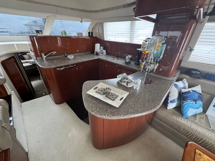 Aqueous Ubiquitous Yacht Photos Pics Luxurious 2004 Sea Ray 560 Sedan Bridge yacht interior with modern kitchen and seating area.