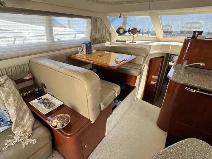 Aqueous Ubiquitous Yacht Photos Pics Luxurious interior of 2004 Sea Ray 560 Sedan Bridge yacht with plush seating and dining area.