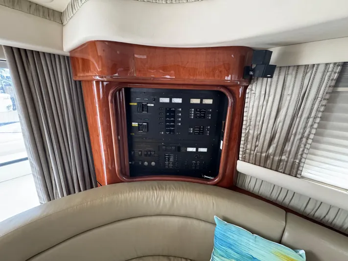 Aqueous Ubiquitous Yacht Photos Pics Electrical panel inside 2004 Sea Ray 560 Sedan Bridge yacht with wood finish and seating area.