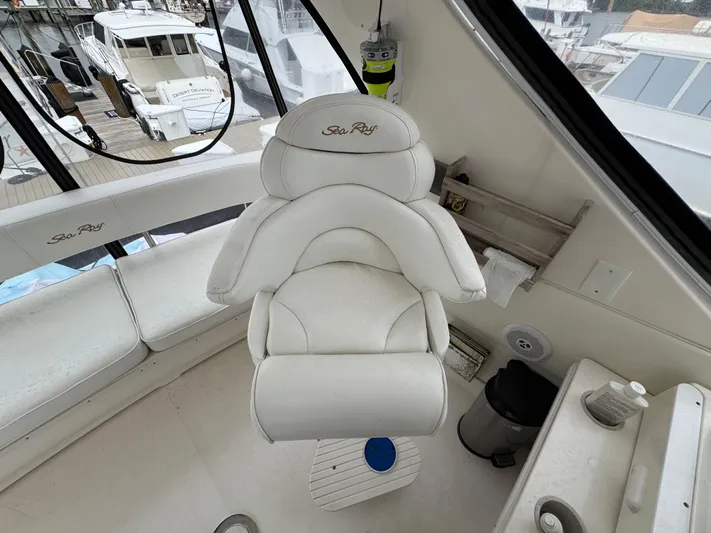 Aqueous Ubiquitous Yacht Photos Pics Captain's chair on 2004 Sea Ray 560 Sedan Bridge yacht, featuring white upholstery and helm view.
