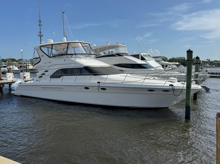Aqueous Ubiquitous Yacht Photos Pics 2004 Sea Ray 560 Sedan Bridge yacht docked at marina under clear blue sky.