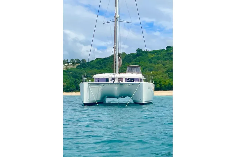  Yacht Photos Pics 2012 Lagoon 400 catamaran anchored near lush green shoreline.