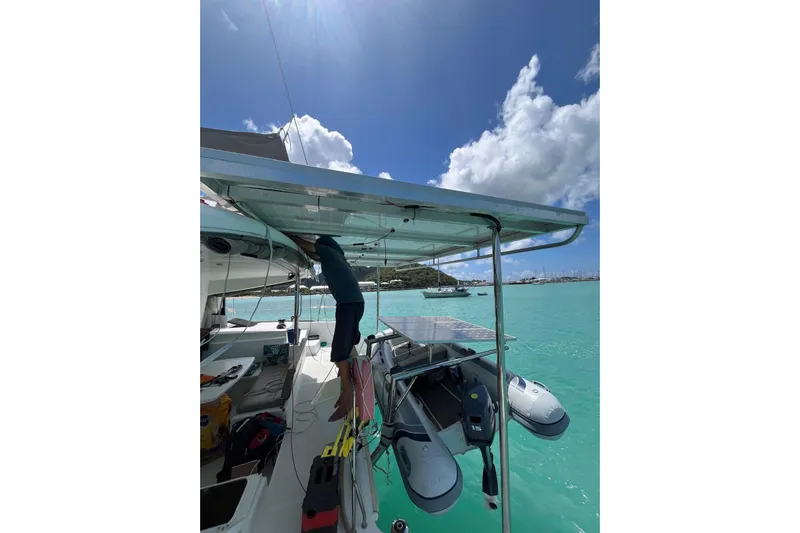  Yacht Photos Pics Man working on Lagoon 400 catamaran, 2012 model, in turquoise waters under sunny sky.