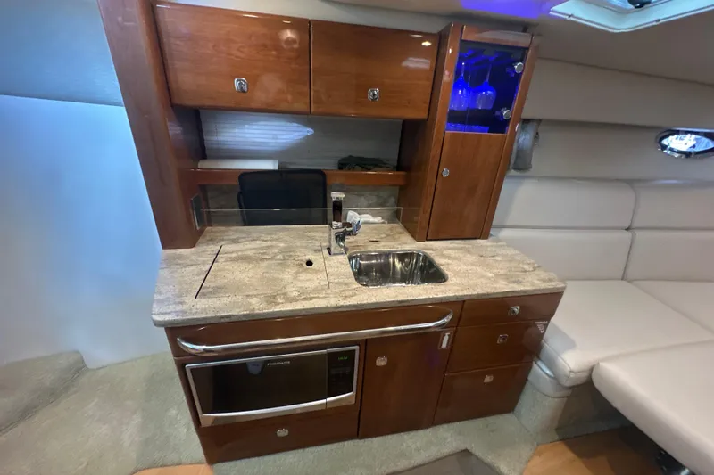  Yacht Photos Pics 2018 Formula 370 Super Sport yacht interior with kitchenette, featuring wood cabinets and modern appliances.