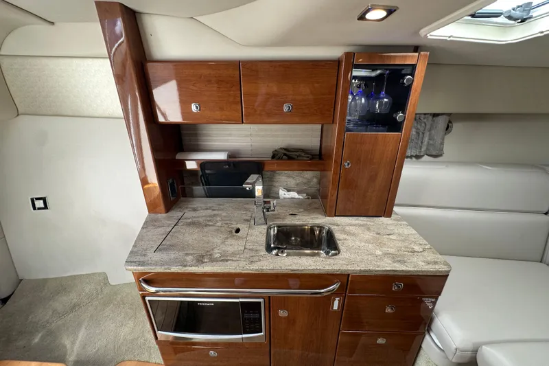  Yacht Photos Pics 2018 Formula 370 Super Sport yacht interior with kitchenette, wooden cabinets, and modern appliances.
