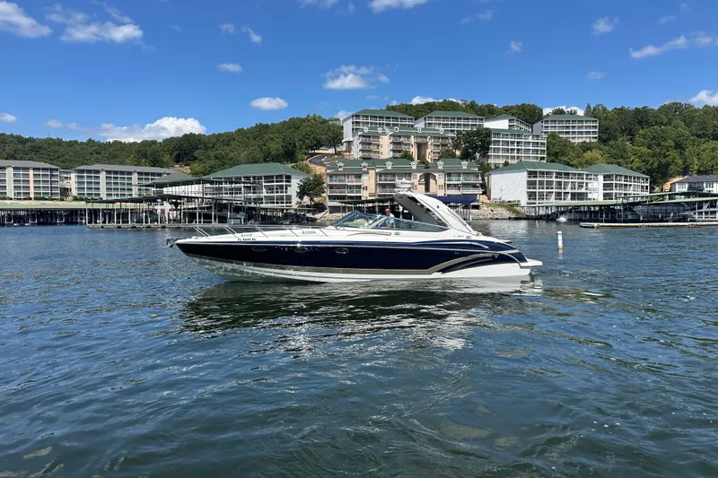  Yacht Photos Pics 2018 Formula 370 Super Sport boat cruising on a lake with scenic waterfront buildings.
