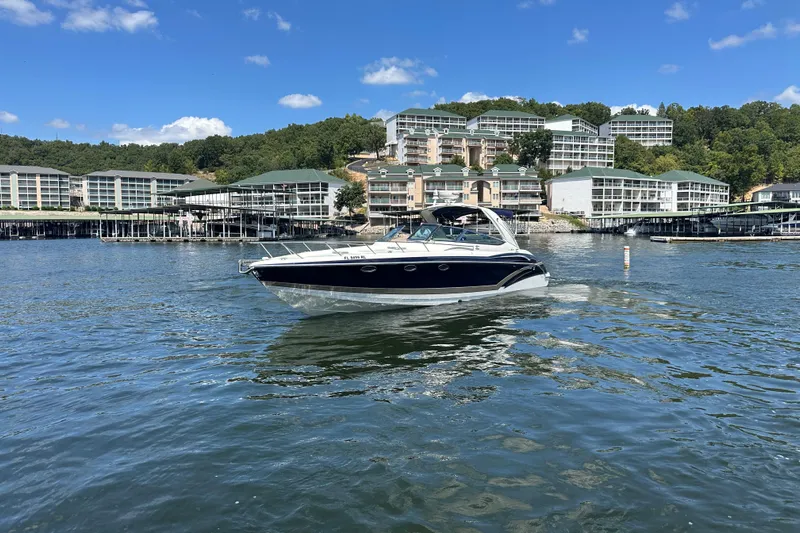  Yacht Photos Pics 2018 Formula 370 Super Sport boat cruising on a lake with waterfront buildings in the background.