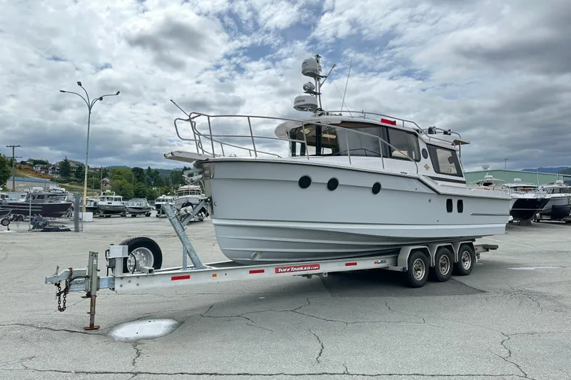  Yacht Photos Pics 2025 Ranger Tugs R-29S boat on a trailer in a marina parking lot.