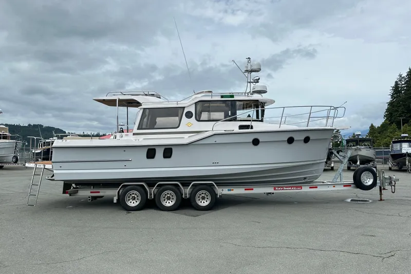  Yacht Photos Pics 2025 Ranger Tugs R-29S boat on trailer, parked outdoors under cloudy sky.