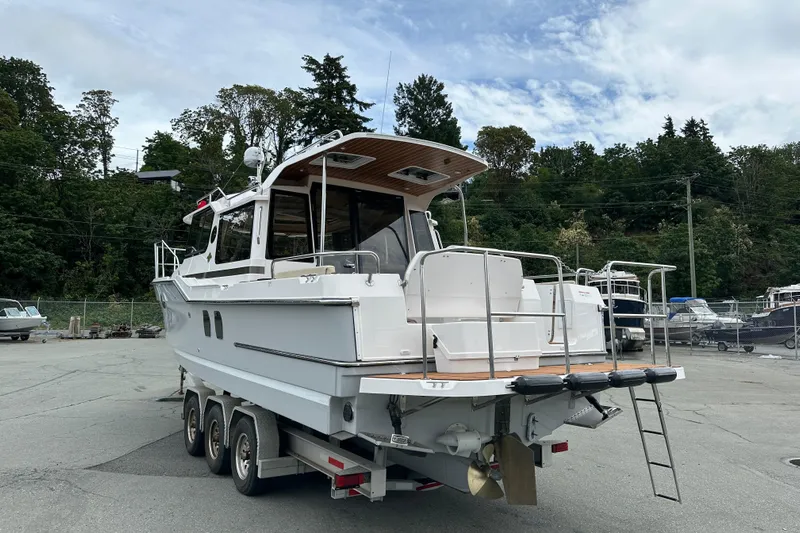  Yacht Photos Pics 2025 Ranger Tugs R-29S boat on trailer, parked outdoors with trees in background.