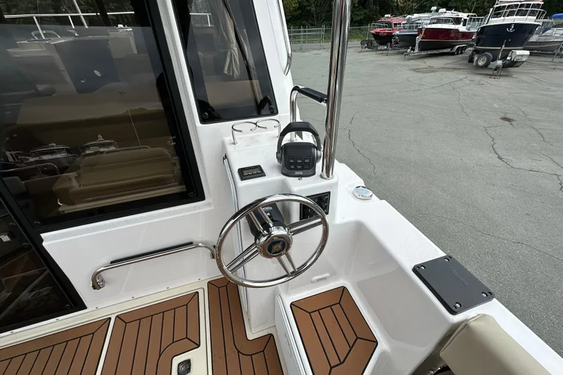  Yacht Photos Pics 2025 Ranger Tugs R-29S boat helm with steering wheel and control panel.