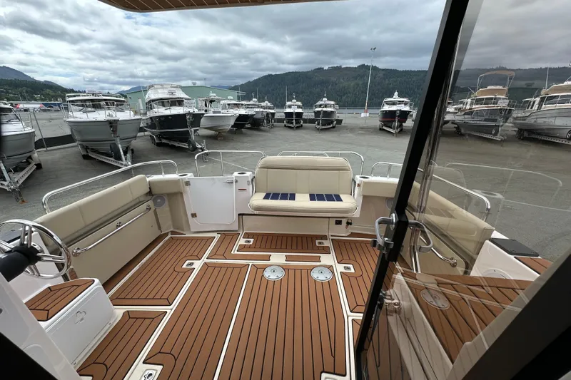  Yacht Photos Pics 2025 Ranger Tugs R-29S boat interior with teak flooring and seating, docked among other boats.