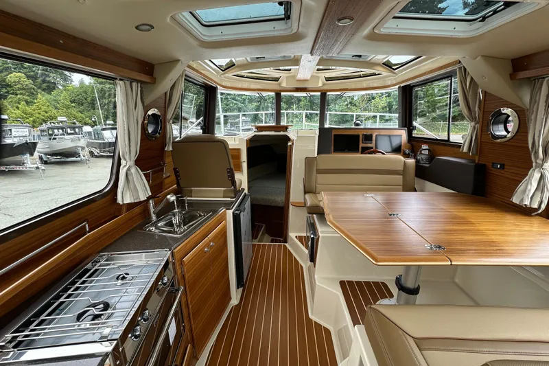  Yacht Photos Pics Interior of 2025 Ranger Tugs R-29S, featuring modern kitchen and dining area with wood accents.