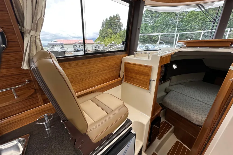  Yacht Photos Pics Interior of 2025 Ranger Tugs R-29S, featuring helm seat and cozy cabin berth.