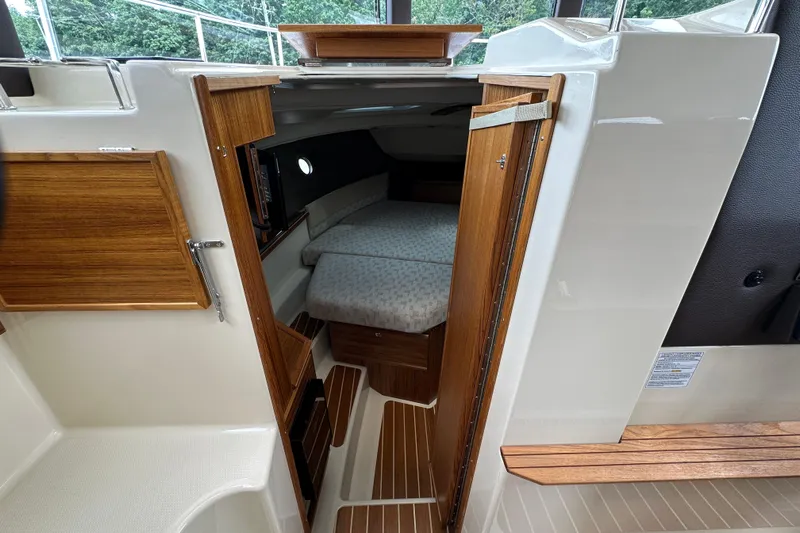  Yacht Photos Pics 2025 Ranger Tugs R-29S interior cabin with wooden finishes and cozy sleeping area.