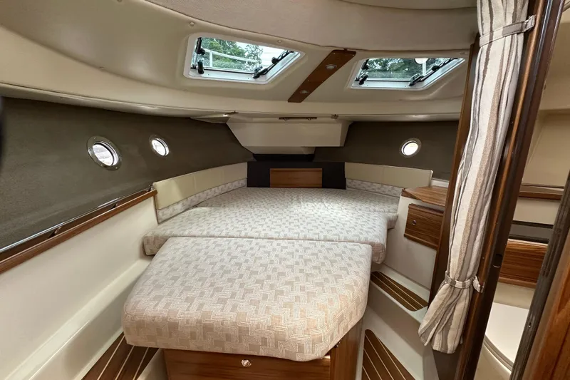  Yacht Photos Pics 2025 Ranger Tugs R-29S interior cabin with cozy bed and elegant wood finish.