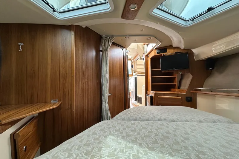  Yacht Photos Pics Interior of 2025 Ranger Tugs R-29S, featuring wood paneling, skylights, and a compact entertainment area.