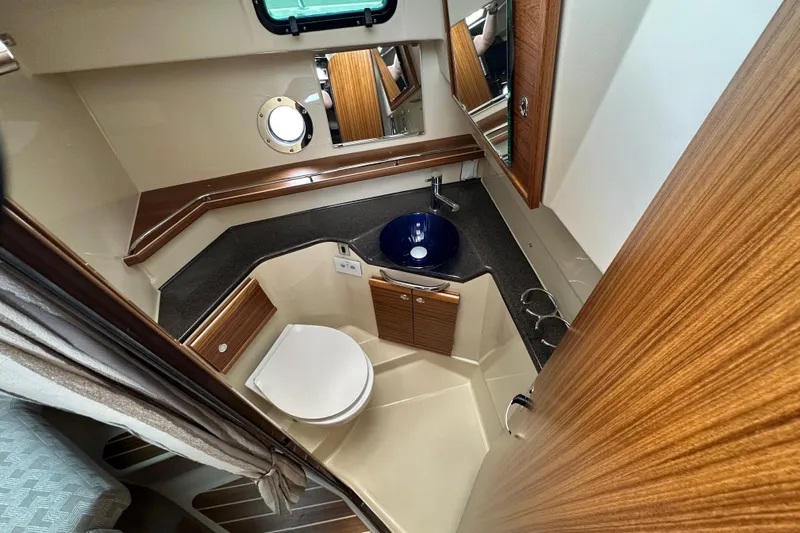  Yacht Photos Pics 2025 Ranger Tugs R-29S bathroom with modern fixtures, wood accents, and a blue sink.