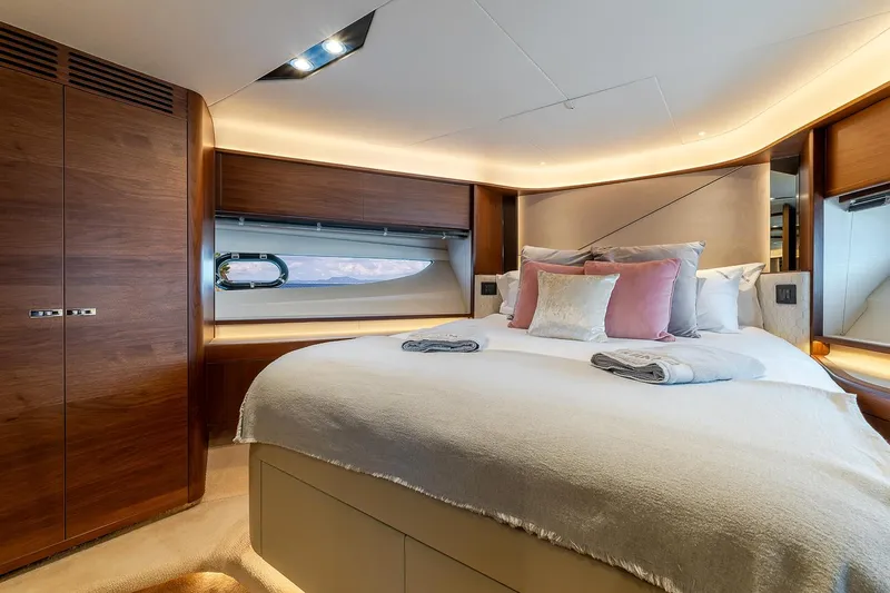  Yacht Photos Pics Luxurious bedroom interior of 2019 Princess S78 yacht with elegant wood finishes and plush bedding.