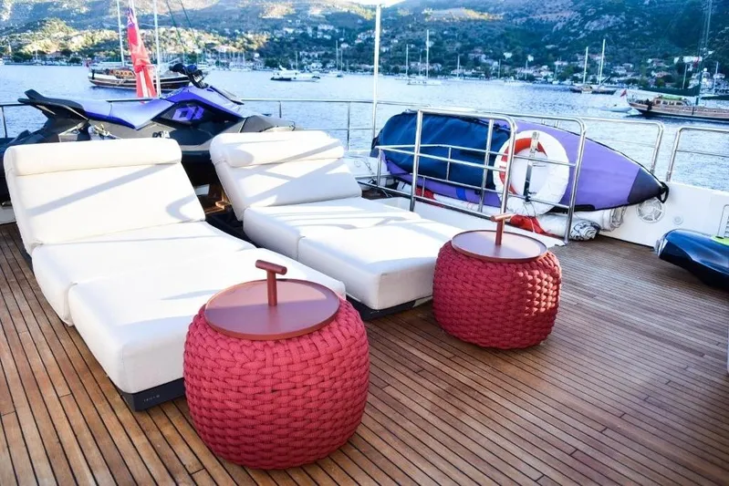  Yacht Photos Pics Luxurious Falcon 102 HT yacht deck with sun loungers and red woven tables, 2008 model.