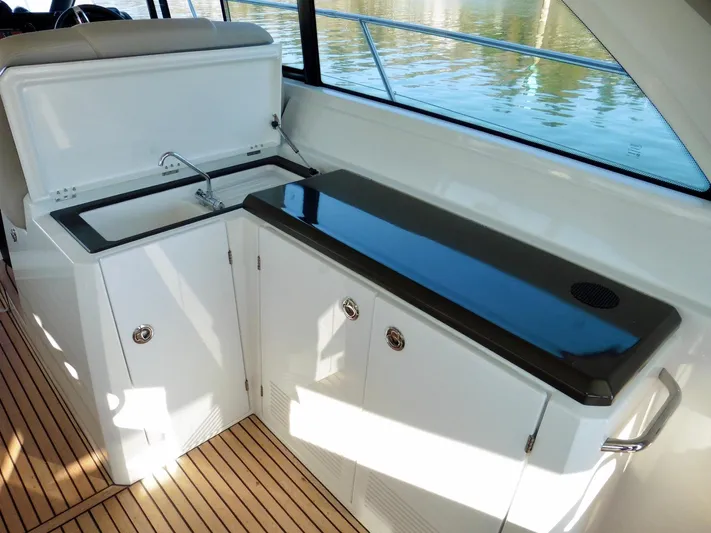  Yacht Photos Pics 2017 Jeanneau Leader 46 yacht interior with sleek kitchenette and wooden flooring.
