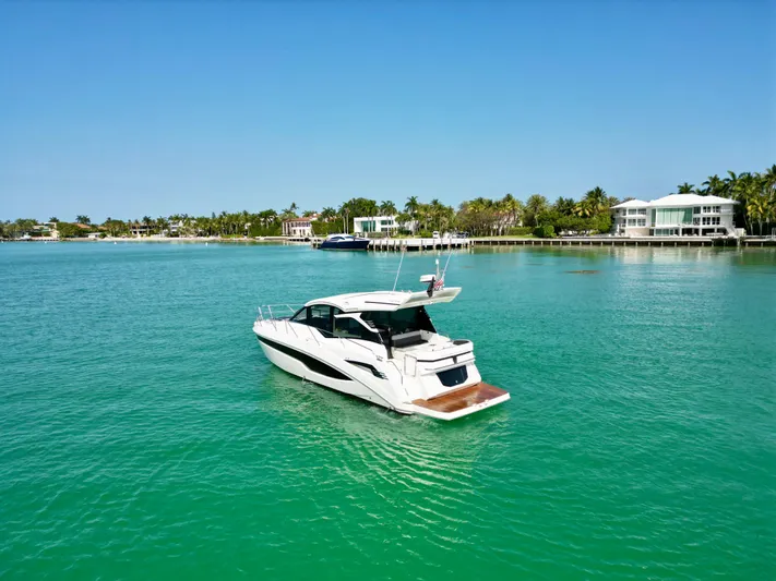  Yacht Photos Pics 2020 Galeon 425 HTS yacht on turquoise water near coastal homes.