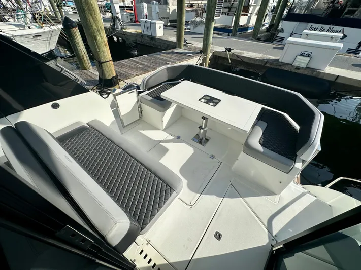  Yacht Photos Pics 2020 Galeon 425 HTS yacht cockpit with cushioned seating and table, docked at marina.