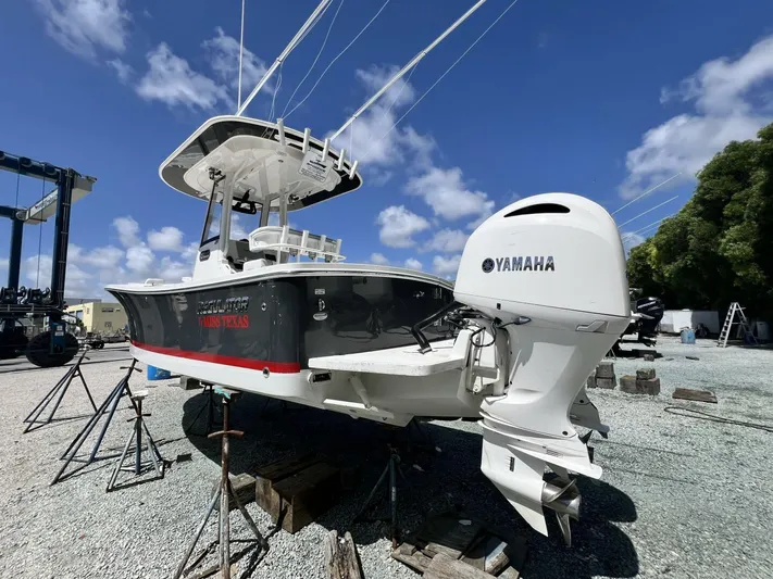 T/t Miss Texas Yacht Photos Pics 2020 Regulator 23 boat with Yamaha engine on dry dock under blue sky.