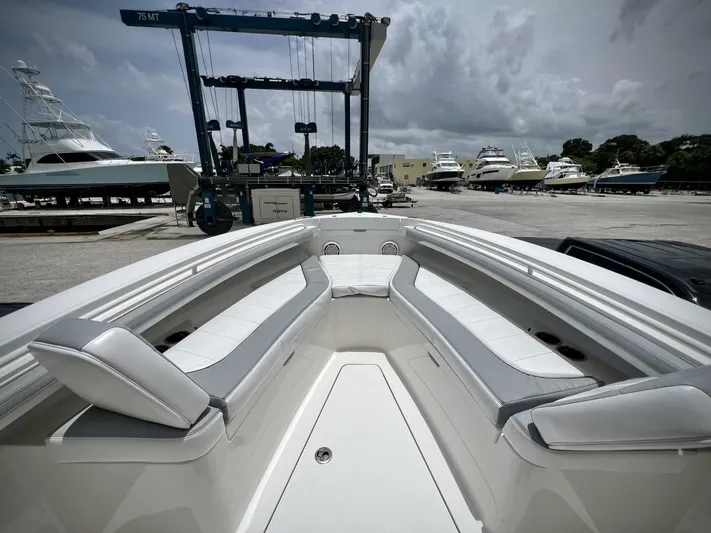 T/t Miss Texas Yacht Photos Pics 2020 Regulator 23 boat interior with seating, docked at marina under cloudy sky.