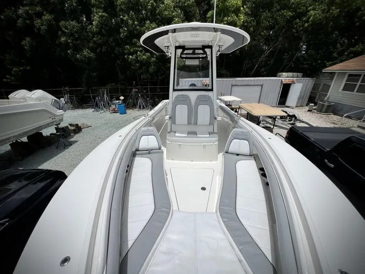 T/t Miss Texas Yacht Photos Pics 2020 Regulator 23 boat with spacious seating and sleek design in a yard setting.