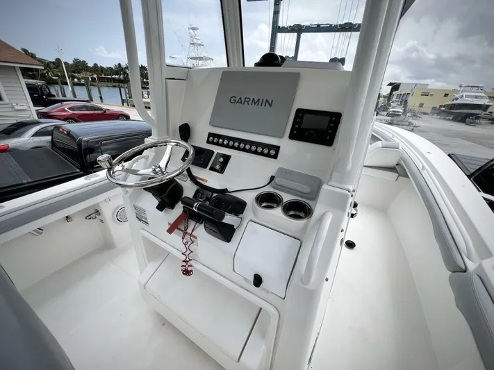 T/t Miss Texas Yacht Photos Pics 2020 Regulator 23 boat console with Garmin navigation system and steering wheel.