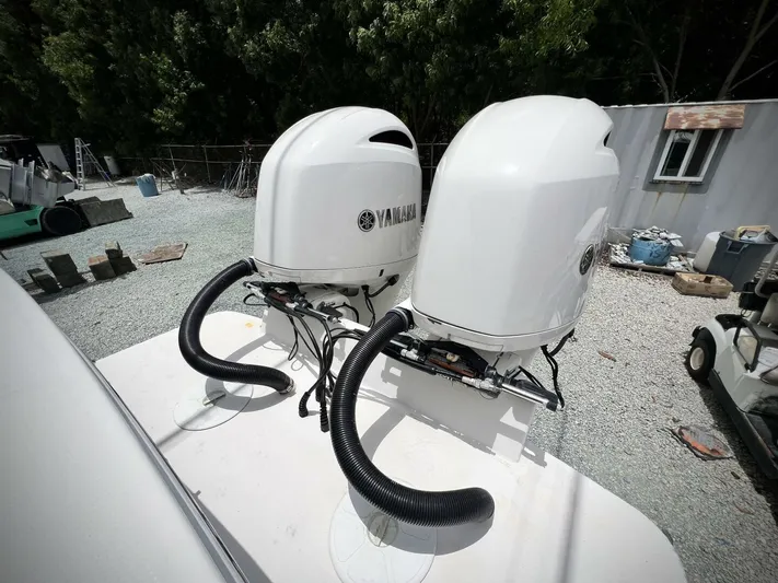 T/t Miss Texas Yacht Photos Pics Twin Yamaha outboard engines on 2020 Regulator 23 boat, parked on gravel.