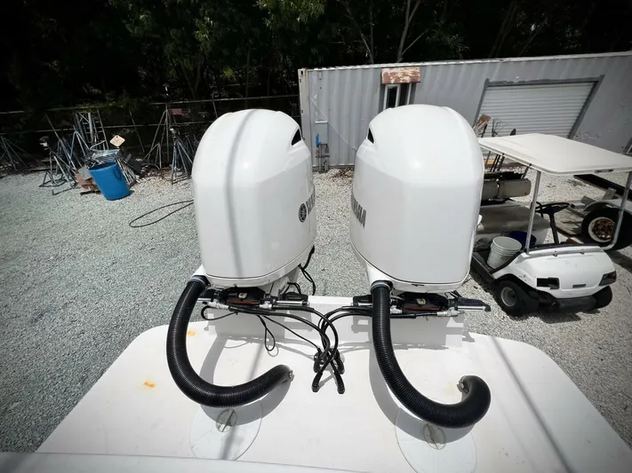 T/t Miss Texas Yacht Photos Pics Twin outboard motors on a 2020 Regulator 23 boat, parked in a gravel lot.