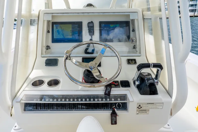  Yacht Photos Pics Control panel of a 2016 SeaVee 340Z boat with steering wheel and navigation screens.