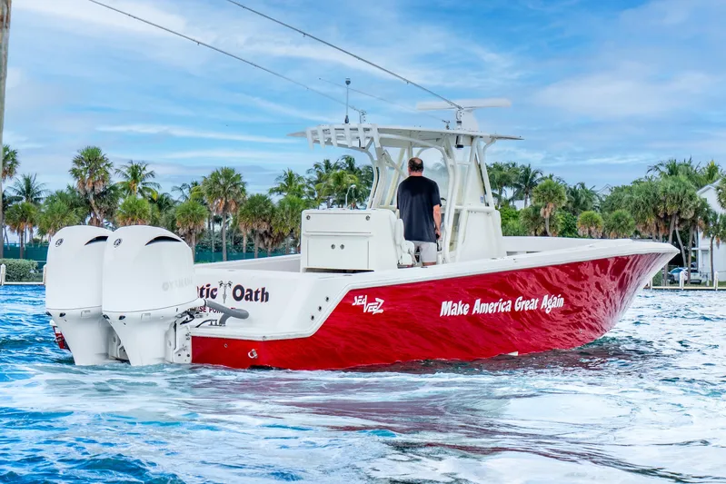  Yacht Photos Pics 2016 SeaVee 340Z boat with red hull, twin engines, and slogan, cruising on water.