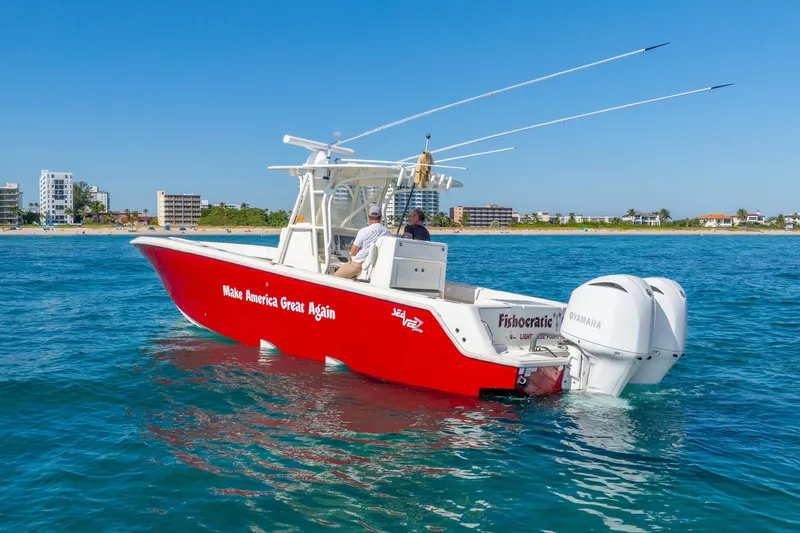  Yacht Photos Pics 2016 SeaVee 340Z boat with red hull, "Make America Great Again" text, on blue ocean near coastline.