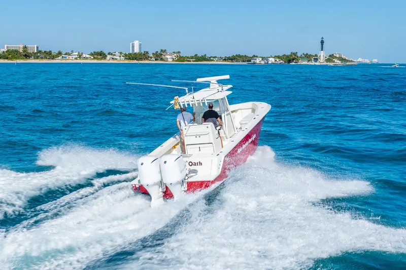  Yacht Photos Pics 2016 SeaVee 340Z boat cruising on blue ocean near coastal buildings.