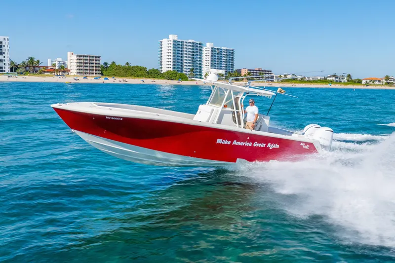  Yacht Photos Pics 2016 SeaVee 340Z boat cruising near a beach, vibrant red hull, clear blue water.