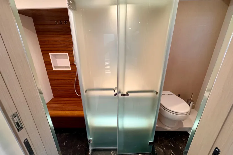  Yacht Photos Pics Luxurious bathroom in 2025 Azimut Fly 68 yacht with frosted glass doors.
