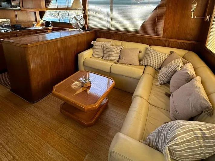  Yacht Photos Pics Luxurious interior of 1989 Hatteras 58 yacht with plush seating and wooden accents.