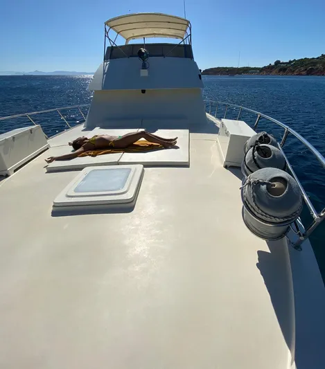  Yacht Photos Pics 1989 Hatteras 58 yacht with person sunbathing on deck, ocean view.