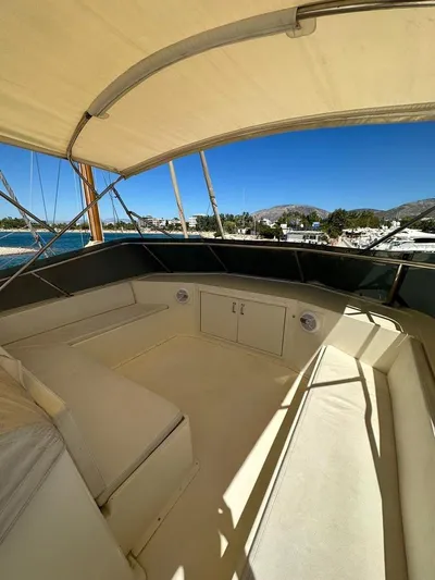  Yacht Photos Pics 1989 Hatteras 58 yacht deck with seating, under a canopy, overlooking marina and mountains.