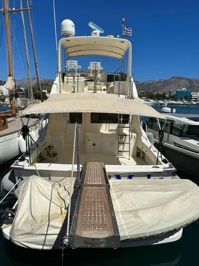  Yacht Photos Pics 1989 Hatteras 58 yacht docked at marina, featuring spacious deck and canopy.