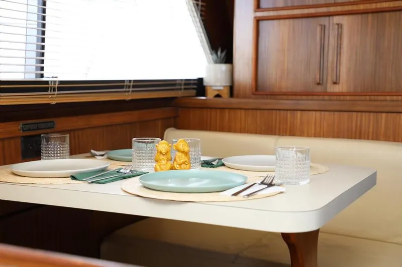  Yacht Photos Pics Dining area in 1989 Hatteras 58 yacht with set table and wooden interior.