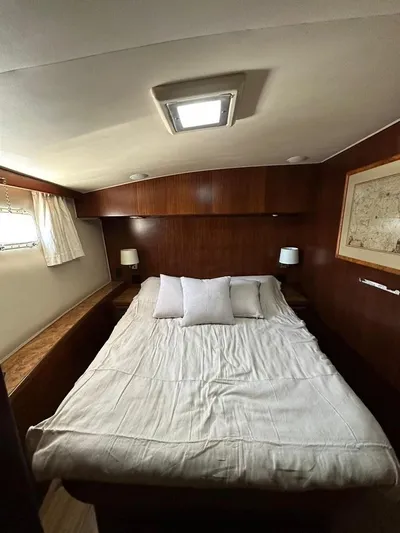 Yacht Photos Pics Cozy bedroom in 1989 Hatteras 58 yacht with wood paneling and soft lighting.